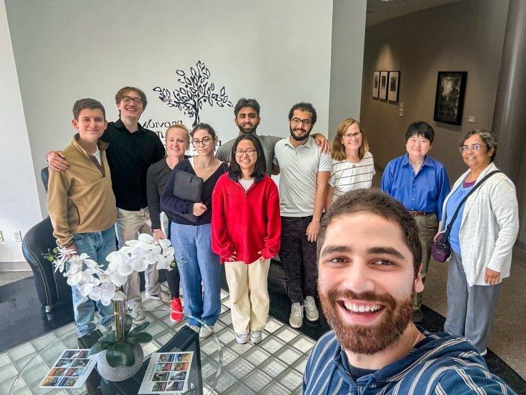 Lawyers and student volunteers take a group selfie after helping refugees in a legal clinic.